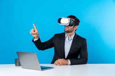 Bilgisayarla masada otururken ve VR gözlüğü takarken veri analizine bakan yetenekli bir iş adamı. Proje yöneticisi sanal gerçeklik sistemini kullanarak ya da metaevrende bağlantı kurarak çalışıyor. Sapma.