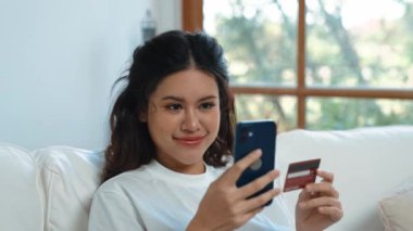 Kadın alışverişi ya da internet pazarında online ödeme modern yaşam tarzı için satılık eşyalar arıyor ve canlı siber güvenlik yazılımı tarafından korunan cüzdandan çevrimiçi ödeme için kredi kartı kullanıyor