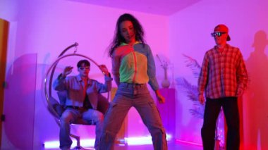 İspanyol hipster renkli kıyafetler giyer ve serbest stil müziğe el sallar. Profesyonel break dansçı neon ışıklarıyla ve modern stüdyo arkadaşlarıyla coşkuyla dans ediyor. Mutluluk.