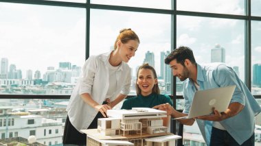 Akıllı mimar takımı ev tasarımı hakkında tartışırken yakışıklı erkek işçi dizüstü bilgisayar kullanarak fikir sunuyor. Profesyonel mühendis paylaşımı, beyin fırtınası tasarımı. İş tasarımı. İzleme