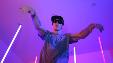 Beyaz dansçının gösterişli gözlükler taktığı ve break dans yaptığı alçak açılı kamera. Çekici adam kendinden emin bir şekilde kameraya bakarken enerjik bir performans ve hareket gösterdi. Mutluluk.