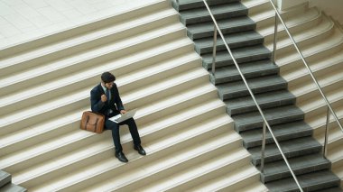 Üst düzey bir iş adamı merdivenlerde otururken başarılı bir projeyi kutluyor. Akıllı proje yöneticisinin yeni bir iş bulması, terfi alması, bilgisayar kullanarak arkadaşlarını arayarak satışları artırması. Sevinçli..