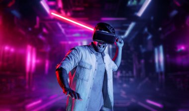 Lazer kılıcı tutan ve VR gözlük takan oyuncu. Beyaz adam, neon şatonun etrafında dikilirken görsel gerçeklik kulaklığı kullanıyor. Yenilik teknolojisi. Sapma.