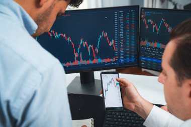 Akıllı telefon üzerinden dijital para birimini tartışan borsa simsarları iki ekranlı gerçek zamanlı çevrimiçi dinamik verilere odaklanarak, modern işyerindeki olası trend yatırımlarını analiz ediyorlar. Satılabilir.
