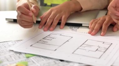 Mimari ekipmanlarla toplantı masasında ev tasarımı üzerine profesyonel mühendis ekibi tartışması ve modern ofiste bina planı dağılımı. Eline odaklan. - Yakın çekim. Tanımlama.