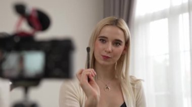 Güzellik ve kozmetik öğretim videosu içeriği yapan kamera görüntüsü kadını ya da perde arkası görüntüsü. Güzellik blogcusu izleyicilere ya da sosyal medya takipçilerine güzellik hizmetinin nasıl uygulanacağını gösteriyor. Blithe