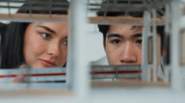 Ev modeli yapısını ölçmek için birlikte çalışan kooperatif mühendisi kapatın. Genç ve güzel mimar ev modelini ölçerken erkek mühendis performansını destekliyor. Tertemiz..