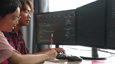 Yavaş çekim arkası yazılım geliştirici mühendisi bilgisayar programlama için birlikte çalışarak hata ayıklama kodunu çözüyor, ofiste monitörde karmaşık algoritmaları çözüyor. Filizlenen