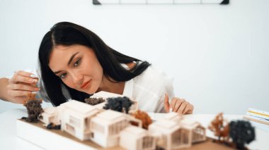 Genç ve güzel mimarın yakın plan portresi modern toplantı odasındaki masaya yerleştirilmiş mimari modeli ölçmeye odaklanıyor. Yaratıcı iş tasarımı konsepti. Tertemiz..