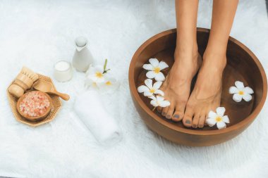 Panorama üstteki kadın lüks spa salonunda mutlu bir ayak masajı yaparken, masör de hafif gündüz atmosfer tesisinde veya otel ayak spasında refleksoloji terapisi uyguluyor. Sessiz.