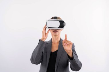 Profesyonel kadın lider programa dokunuyor ya da sanal gerçeklik gözlüğü kullanırken çalışıyor. Yetenekli iş kadını, görsel gerçeklik gözlüğü takarak metaevrene bağlanırken sistemi işaret ediyor. Kısıtlanma.