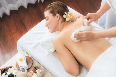Sıcak bitkisel top spa masaj vücut tedavisi, masör kadın vücuduna nazikçe şifalı bitki torbası bastırıyor. Aromaterapi dinlenme sükuneti ve sükuneti kaplıca salonundaki atmosferi aydınlatıyor. Sessiz.