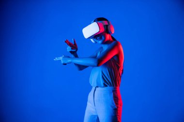 VR kulaklık takan zeki bir kadın metaevrene bağlanıyor, gelecekteki siber uzay topluluğu teknolojisi. Sanal silaha hükmeden zarif bir kadın ciddi ciddi oyun oynuyor. Halüsinasyon.