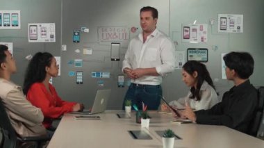 Bir grup profesyonel iş adamı Ux ve Ui tasarımı hakkında konuşuyor. İşbirlikçi çeşitli iş adamları pazarlama planı hakkında beyin fırtınası yapıyor. Birlikte çalışan iş adamları. Yönlendirici.