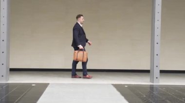 İş adamlarının bavul tutarken ve şehir merkezindeki iş yerine yürürken yan görüntüsü. Profesyonel proje yöneticisi dışarıda resmi takım elbise giyerken toplantıya gidiyor. Urbane.