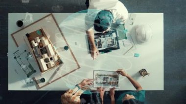 Yetenekli mimar mühendisinin birlikte çalışması ve küresel bağlantı hologramıyla kooperatif ekibe fikir vermesi. Yöneticinin dikilip plandan bahsedişinin havadan görüntüsü. Hizalama.