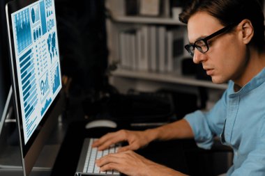 Akıllı iş adamı iş paragrafı dinamik pazarlama analizi planını analiz ediyor. Kağıt kağıtları ve bilgisayar monitörü raporlarını gece evdeki belge verileriyle karşılaştırmak için hazırlıyor. Bireysel.