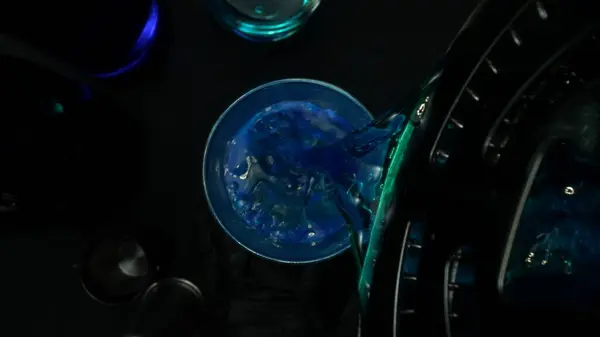 stock image Macrography, witness the artful mixing of a Blue Hawaii cocktail against a dramatic black background. Each close-up shot captures the vibrant colors and swirling motion of blue cocktail. Comestible.