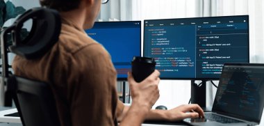 Bilgisayar ekranında program kodlama veritabanı işi projesi yaratırken aynı zamanda kahve içen IT geliştiricisi olarak çalışmak, modern ofisteki web sitesinde en son sürüm uygulaması için düşünme programı. Toplayıcı.