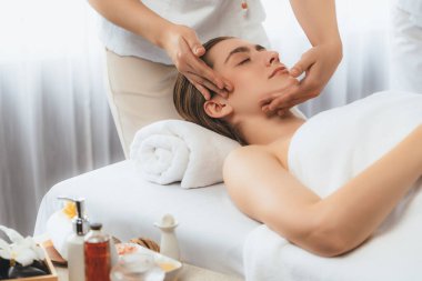 Kafkasyalı kadın stres önleyici kafa masajından ve lüks tatil beldesi ya da otel spa salonundaki modern ışık ortamında yüz güzelliği eğlencelerini şımartmaktan hoşlanıyor. Sessiz.