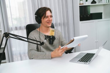 Akıllı yayıncının sunucu kanalı canlı sosyal medya yayını ile dinleyicilere senaryo okuyarak, kulaklık takarak modern ev stüdyosundaki video flamalarını kaydediyor. Bireysel.