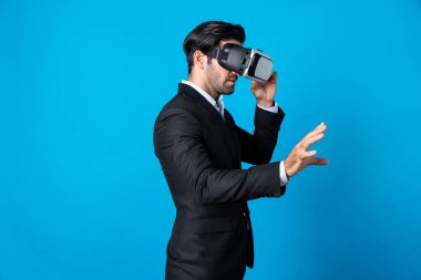 Profesyonel, zeki iş adamı, VR gözlük takarken elinde bir şey tutuyor. Sanal gerçeklik gözlüklü Kafkas proje yöneticisi mavi arka planlı mevcut teknoloji yeniliği. Sapma.