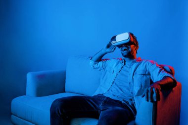 Komik film izlemek için VR gözlük takan mutlu bir adam. Beyaz insan, sanal ya da metaevrensel sanal dünyaya bakarken VR teknolojisiyle yenilik yaparak rahatladı. Sapma.