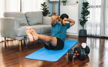 Atletik ve sporcu adam, evde vücut egzersizi yaparken spor ve spor yaşam tarzına uyum sağlamak için spor minderinde çatırdıyor. Gaiety ev egzersizi antrenman konsepti.
