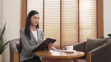 Mutlu ve gülümseyen kadın psikolog psikiyatri ofisinde ya da terapi odasında pano tutuyor. Arkadaş canlısı ve profesyonel ruh sağlığı danışmanı ya da terapisti. Blithe