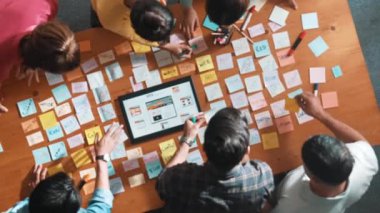 Ux Ui tasarımı kullanılarak dijital program ve yazıları tartışan ve gösteren geliştirici ekibin hava görüntüsü. İş dünyasına tepeden bakan insanlar telefon ve bilgisayar için kablo prototipi geliştiriyorlar. Sempozyum.