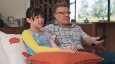 Büyükbaba ve torun birlikte TV 'de ilginç bir eğlence medyası izliyorlar. Eski üst düzey kullanım teknolojisi, genç nesil çapraz nesil ile iletişim kurarak aile bağlarını güçlendiriyor. Uyumsuzluk.