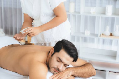 Kafkas erkek müşteri stres önleyici spa masajının keyfini çıkarıyor ve lüks otel veya oteldeki gündüz açık hava ortamında güzellik derisi eğlencesi ile şımartıyor. Sessiz.