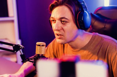 Oyun kanalı, online oyun oynayan akıllı flamalı oyun sunucusu, kulaklık takan, neon ışıklandırma odasındaki takım oyuncusuyla akıllı telefondan canlı yayında konuşan izleyiciler. Bireysel.