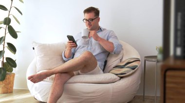 Orta yaşlı bir adam, iş için telefon arama verilerini kullanarak, çocukları iyi bir yetişkin ya da eğlence olsun diye odada kahve fincanıyla koltukta oturur. İşadamı teknolojiyi kolaylık için kullanır. Uyumsuzluk.