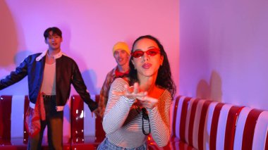Çok kültürlü bir arkadaş birlikte dans ediyor ve hiphop müziği eşliğinde restoranda ya da kafede pembe neon ışıklı duruyor. Profesyonel sokak dansçıları grubu enerjik hareketler sergiliyor. Mutluluk.