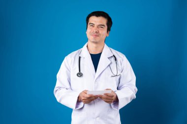 Gülümseyen zeki doktor, elinde şeffaf tablet tutarak hastalık araştırma verilerini, tedavi amaçlı gelecekteki tedavi teknolojisini, sağlık hizmetleri yenilik arayüzü hologram ekranını seçerek açıklıyor. Entrika.