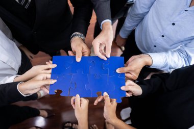 Üst düzey iş adamları yapboz parçalarını tutuyor ve bunları etkili çözüm çözümleri olarak birleştiriyor. Takım çalışması, ortak görüş ve çeşitli yetenekleri birleştiren ortak hedef. Çok titiz.