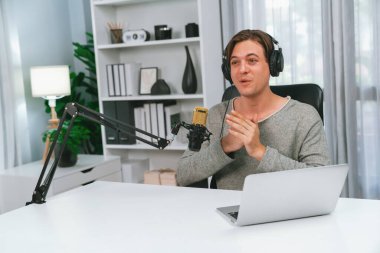 Sunucu kanalı, gülümseyen akıllı yayıncı kaydı, senaryosu ve akıllı telefonuyla sosyal medyada sohbet programı, kulaklık takarak modern ev stüdyosundaki video flamalarını kaydediyor. Bireysel.