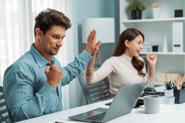 Gülümseyen mutlu iş arkadaşları beşlik çakıyor aynı zamanda yaratıcı proje planını yumrukluyor ve sabahları modern ofiste gündelik işlerde en yüksek kârı elde ediyorlar. Varsayım.