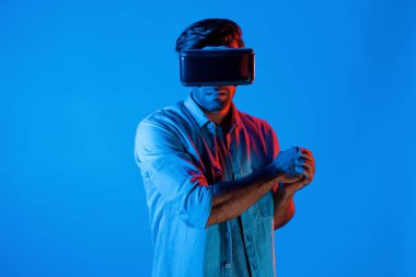 Kafkasyalı bir adam VR cam takıyor ve hareket eden el kol kılıcını tutuyor. Oyuncu, gelecekteki sanal gerçeklik kulaklığını ya da gelecekteki yenilikleri kullanarak meta dünyaya giriyor ya da aksiyon oyunu oynuyor. Sapma.