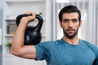 Atletik vücut ve aktif sporcu, sağlıklı vücut çalışma yaşam biçimi konsepti olarak eğlence evinde kas kazancı için kettlebell ağırlığını kaldırıyor..