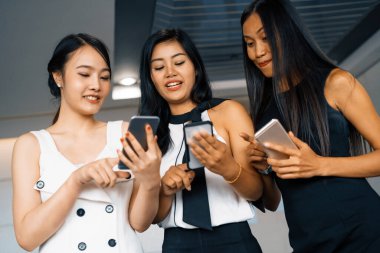 Üç kadın arkadaş ellerinde cep telefonuyla sohbet ediyorlar. Sosyal medya, dedikodu haberleri ve online alışveriş kavramı. uds