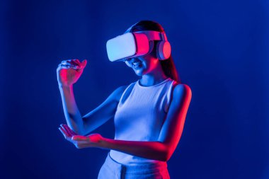 Akıllı kadın, her iki elini de sanal nesne ile etkileşime sokarak metaevreni, gelecekteki siber uzay topluluğunu birbirine bağlayan neon ışıklı bir kulaklık takıyor. Halüsinasyon.