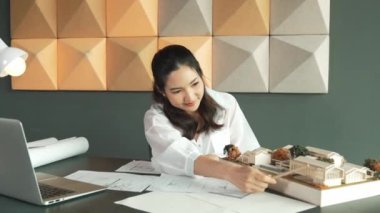 Genç, güzel mimar mühendisinin kalemle ölçüm yaptığı yere yakın çekim. İç mimar, tasarım evinin yapısını kalemle işaret ediyor. İş tasarımı konsepti. Geçmişi bulanıklaştırıyor. Yönlendirici.