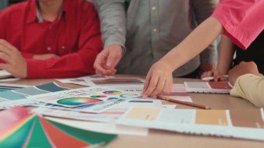 Grafik tasarımı için beyin fırtınası yapan ve renk seçimi yapan tasarımcı ekibinin yavaş çekim çekimi veya tasarım bürosunda krom danışmanlığı için danışmanlık isteyen bir müşteri. Değiştirilmiş