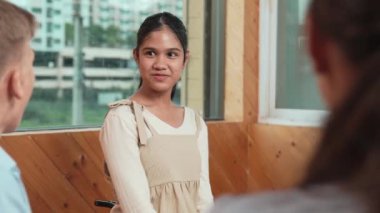 Genç öğrenci toplantıda veya grup tartışmasında diğer öğrencileri dinlerken gülümsüyor. Tecrübelerinden ve karışık ırktan arkadaşlarıyla paylaştığından bahseden sevimli bir genç. Yaratıcı eğitim. Öğretim