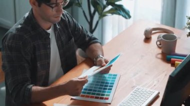 Toplantıda profesyonel tasarımcı yazma ve logo grafiği tasarlama. Renkli paletler üzerinde çalışan iş adamlarının yakınlaşması ve masaya kağıt ve ekipman ile yapışkan notlar yazmak. Sempozyum.