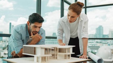 Kooperatif mimar mühendis ekibi kalem kullanarak ev modelini ölçmek için birlikte çalışıyor. Başarılı bir Kafkas iç mimari tasarım ekibi mimari model yapısını inceliyor. Tasarım. İzleme