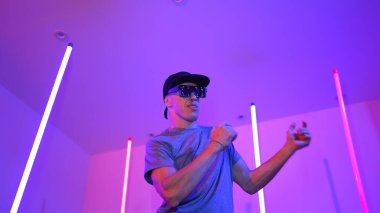 Beyaz dansçının gösterişli gözlükler taktığı ve break dans yaptığı alçak açılı kamera. Çekici adam kendinden emin bir şekilde kameraya bakarken enerjik bir performans ve hareket gösterdi. Mutluluk.