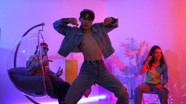 Çok kültürlü bir arkadaş kürsüde otururken Asyalı yetenekli bir dansçı modern müziğe geçiyor. Profesyonel dansçı, hipster takımı tezahürat yaparken ve desteklerken enerjik adımlar atıyor. Mutluluk.